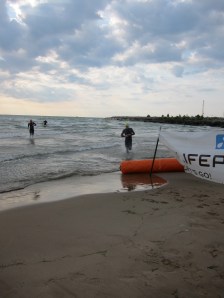 Pro triathletes pop up from the surf like liquid cyborgs
